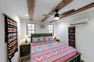 ein Schlafzimmer mit einem Bett, zwei Nachttischen und zwei Fenstern in der Unterkunft Casa Escondida in Santa Fe