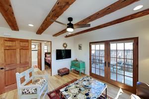 ein Wohnzimmer mit einem Deckenventilator und einem Tisch in der Unterkunft Casa Escondida in Santa Fe