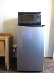 a microwave sitting on top of a refrigerator at American Inn in Ontario