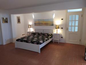 a bedroom with a bed and two night stands with lamps at Tra mare e bosco nella splendida Quercianella in Quercianella