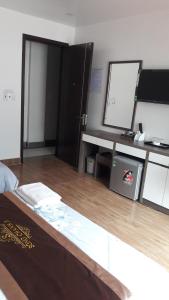 Habitación con cama, escritorio y espejo. en Khách sạn Sông Chanh 3 Cát Bà, en Cat Ba