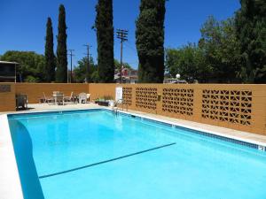 uma grande piscina com cerca e árvores em American Inn em Ontario