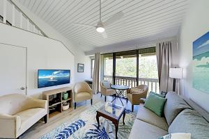 uma sala de estar com um sofá e uma televisão em Turtle Bay Resort 132 em Kahuku