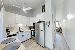 a kitchen with white cabinets and a stainless steel refrigerator at Turtle Bay Resort 132 in Kahuku