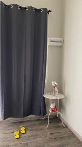 a black shower curtain with a table and yellow slippers at HOMESTAY ASTON GARDEN KB in Kota Bharu +12 photos