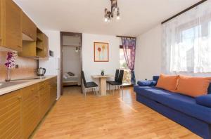 ein Wohnzimmer mit einem blauen Sofa und einer Küche in der Unterkunft Apartments Little spring in Vodice
