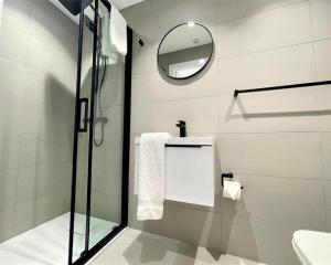 a bathroom with a shower and a sink and a mirror at Luxury Reno'd 1 Bed Nr Bruntsfield & The Meadows in Edinburgh