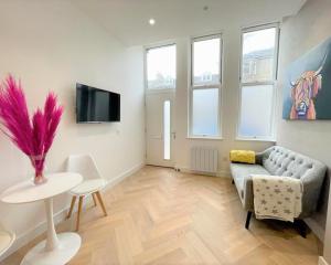 a living room with a couch and a table at Luxury Reno'd 1 Bed Nr Bruntsfield & The Meadows in Edinburgh