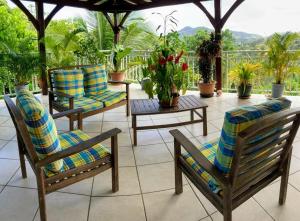 a patio with chairs and a table with plants at Haut de Villa chez Ghighi in Abondance