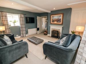 a living room with two couches and a fireplace at Black Horse Cottage in Northallerton