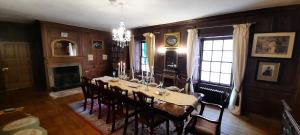 uma sala de jantar com uma mesa longa e cadeiras em East Wing Lickleyhead Castle em Auchleven