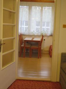 uma sala de jantar com uma mesa e uma janela em Apartman Hruba Skala em Hrubá Skála