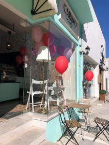 a store front with red balloons and a table and chairs at Katsikantaris Homes in Paphos City
