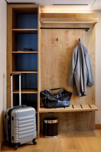 a walk in closet with a suitcase and a coat at Hotel California in Zürich