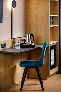 a blue chair sitting in front of a desk at Hotel California in Zürich