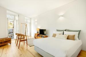 biała sypialnia z dużym łóżkiem i telewizorem w obiekcie InBloom Apartments w Porto