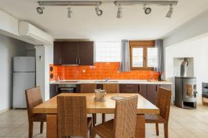 a kitchen with a wooden table and some chairs at #FLH - Vitamin Sea Beachfront Villa, Sithonia in Metamorfosi