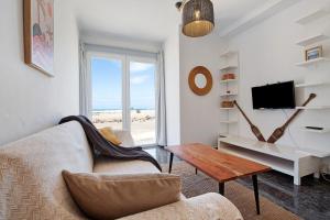 a living room with a couch and a table at El Cotillo Mar Sea View in Cotillo