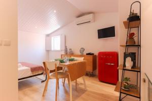 リスボンにあるAlfama Suite by Homingのテーブル、ベッド、赤い冷蔵庫が備わる客室です。