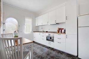 a kitchen with white cabinets and a wooden table at El Cotillo Mar Sea View in Cotillo