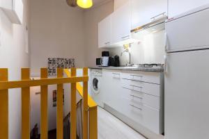 リスボンにあるBairro Alto Cosy by Homingのキッチン(白い冷蔵庫、食器洗い機付)