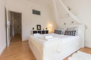 リスボンにあるBairro Alto Stylish by Homingの白いベッドルーム(枕付きの大きな白いベッド付)