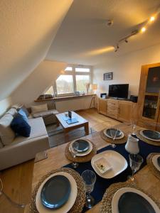 a living room with couches and a table with plates on it at Ferienwohnung Uttied in Baltrum