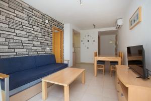 ベニドルムにあるAlameda Apartmentsのリビングルーム(レンガの壁に青いソファ付)