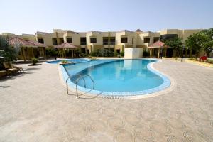 a large swimming pool in the middle of a courtyard at The Sky Imperial Bapu's Resort in Dwarka