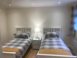 a bedroom with two beds and a lamp on a night stand at Christina’s View in Fort William