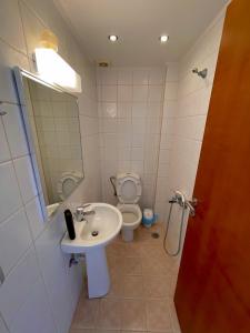 a bathroom with a sink and a toilet at Infinity view - Few steps away from the sea. in Agia Pelagia +1 photo