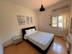 a bedroom with a bed and a window at Infinity view - Few steps away from the sea. in Agia Pelagia