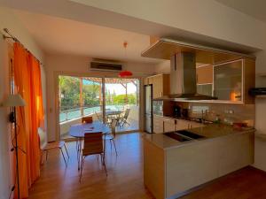a kitchen and dining room with a table and a view at Infinity view - Few steps away from the sea. in Agia Pelagia