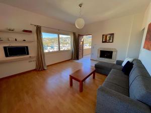a living room with a couch and a fireplace at Infinity view - Few steps away from the sea. in Agia Pelagia
