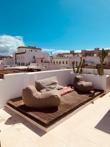 a white couch sitting on top of a white tile floor at Apartamentos Caravane in Tarifa