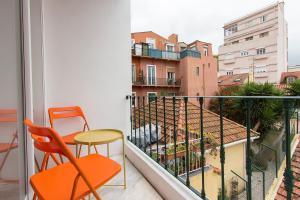 リスボンにあるSanta Marta Views by Homingの景色を望むバルコニー(オレンジの椅子、テーブル付)