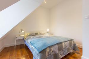 リスボンにあるSanta Marta Views by Homingの白いベッドルーム(ベッド1台、ナイトスタンド付)