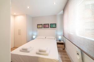 um quarto com uma cama branca e 2 toalhas em MintyStay - Conde de Miranda em Madri