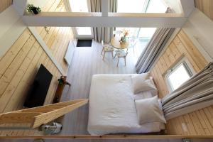 an attic bedroom with a bed and a table at Tiny house - optioneel met hottub in Dokkum