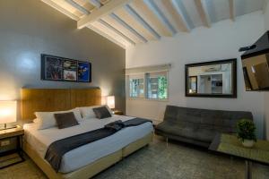 a bedroom with a large bed and a couch at Hotel Aromax del Campestre in Medellín +16 photos