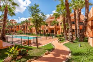 a resort with a swimming pool and palm trees at Ipanema Paradise - Apartamento de dos dormitorios en el Mar Menor in Los Alcázares