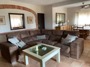 ein Wohnzimmer mit einem braunen Sofa und einem Tisch in der Unterkunft Las Chorreras del Orejón 1 in Villaviciosa de Córdoba