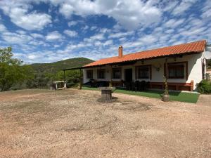 une petite maison blanche avec un toit rouge dans l'établissement Las Chorreras del Orejón 1, à Villaviciosa de Córdoba