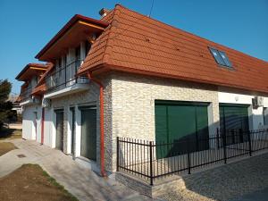 una casa con porte verdi e tetto rosso di Szellőrózsa Apartman a Fonyód