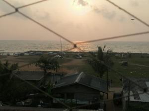 a view of the ocean from a house with a window at Le Petit Hotel & Restaurant in Negombo