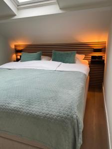 a bedroom with a large bed with a wooden headboard at Beach House Zandvoort in Zandvoort
