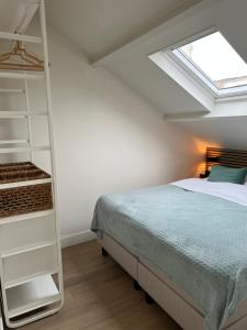 1 dormitorio con 1 cama y tragaluz en Beach House Zandvoort, en Zandvoort