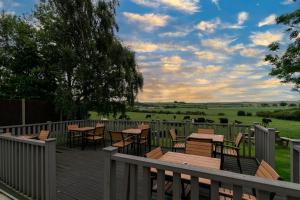 a deck with tables and chairs and a view of a field at Three Horseshoes Inn in Durham