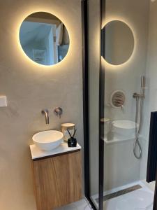 La salle de bains est pourvue d'un lavabo et d'une douche. dans l'établissement Beach House Zandvoort, à Zandvoort