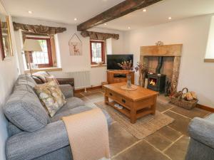 a living room with a couch and a fireplace at Hope Cottage in Bakewell